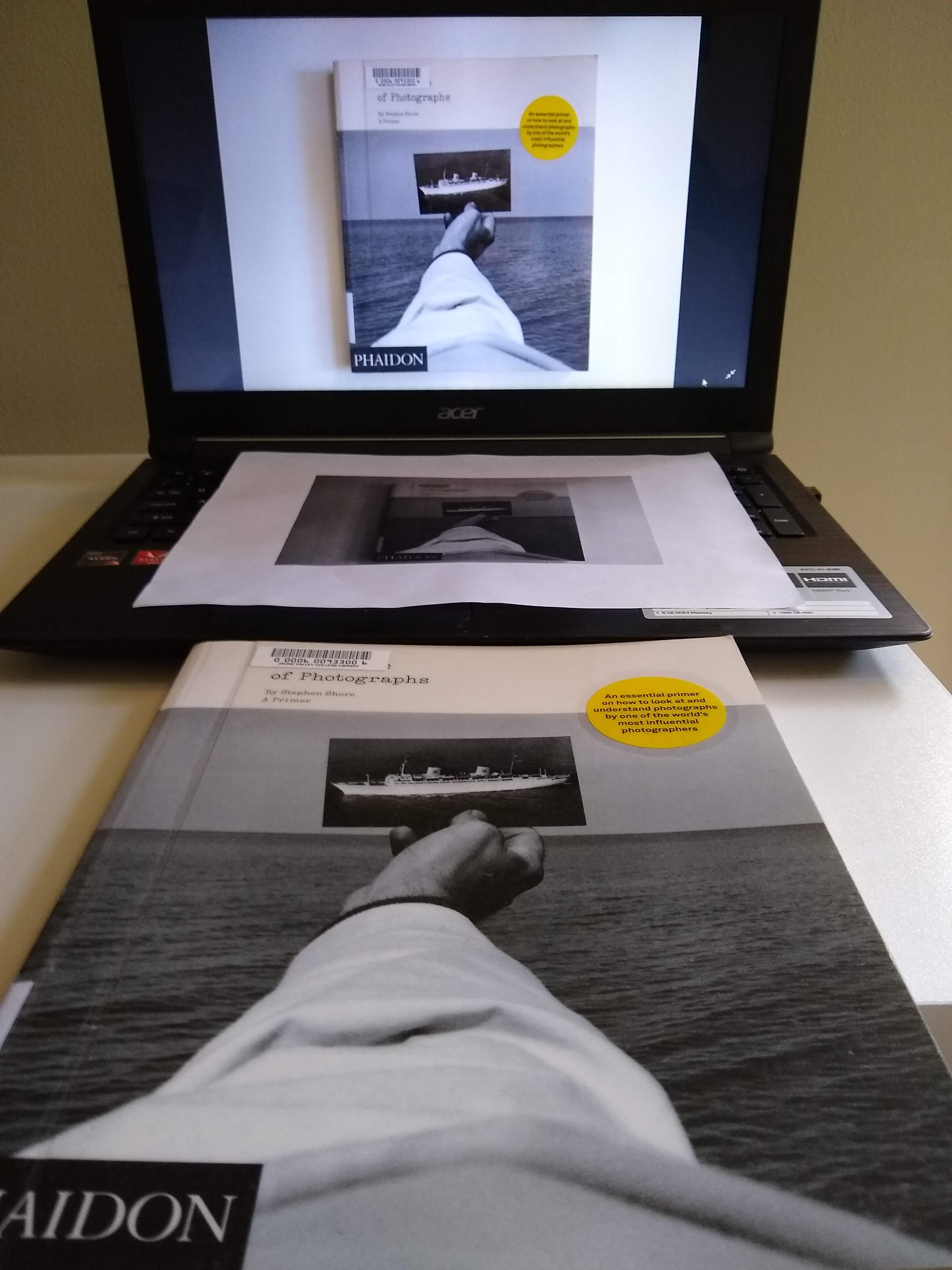 Photo of The Nature of Photographs physical book, printed cover, and image on computer, showing simulacra for book review.