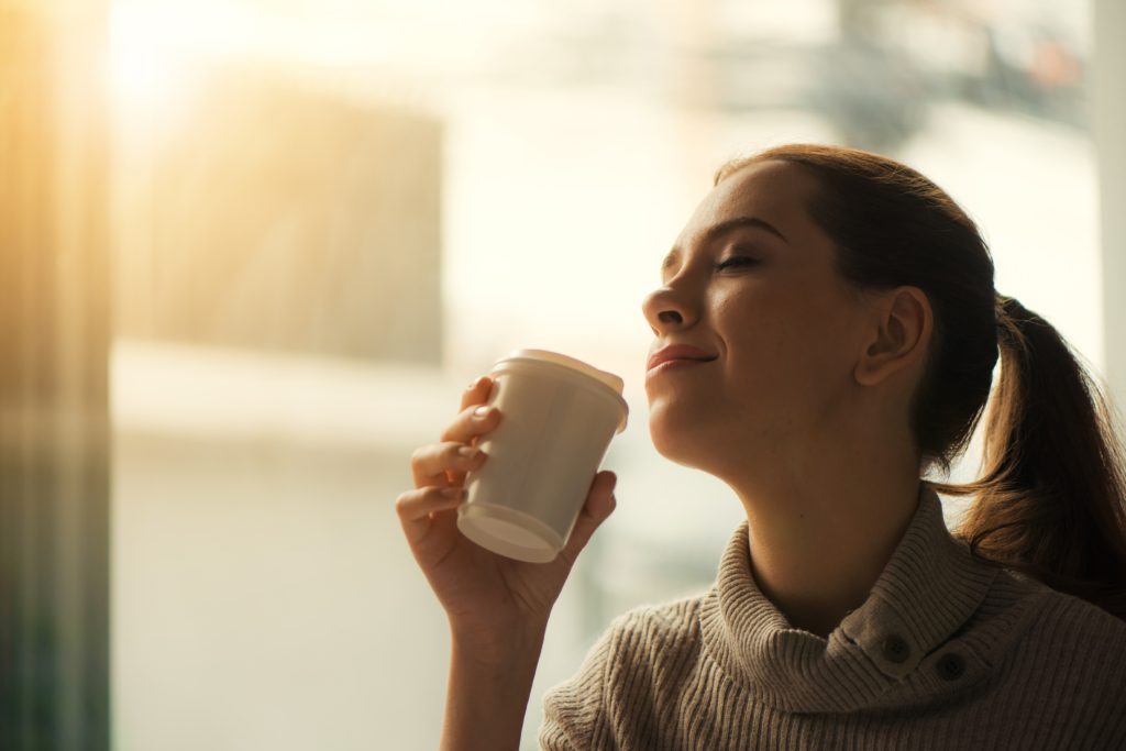 Image of an open mic live poetry reading audience member smelling coffee.