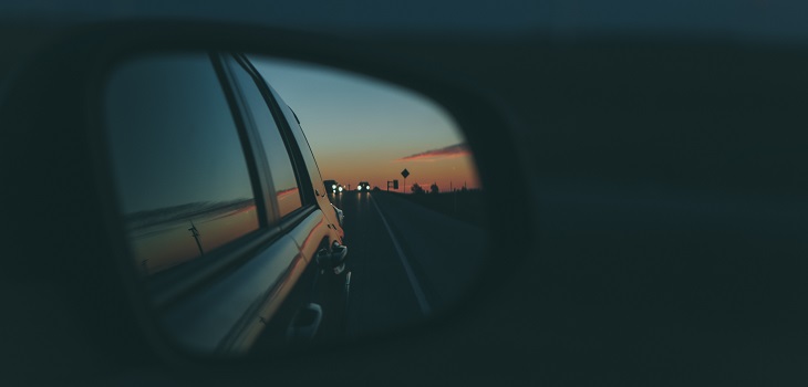 A photo of a rearview mirror on a car representing travel poetry