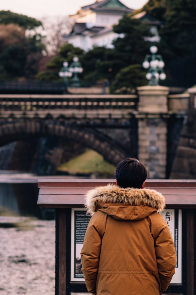 Tourist reading plaque outside Imperial Palace in Tokyo, Japan.